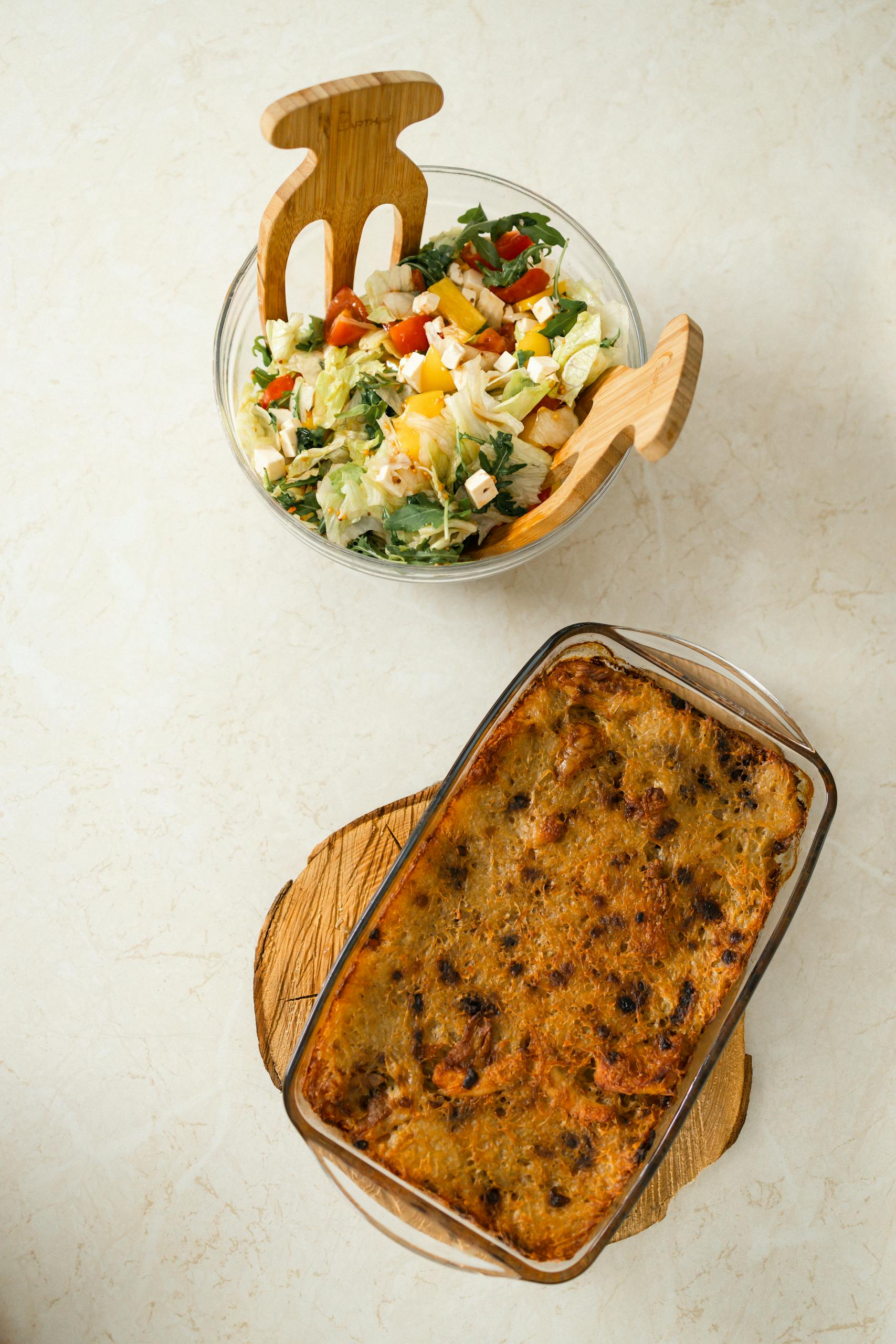 Delicious gourmet baked dish paired with a refreshing salad, captured from above.
